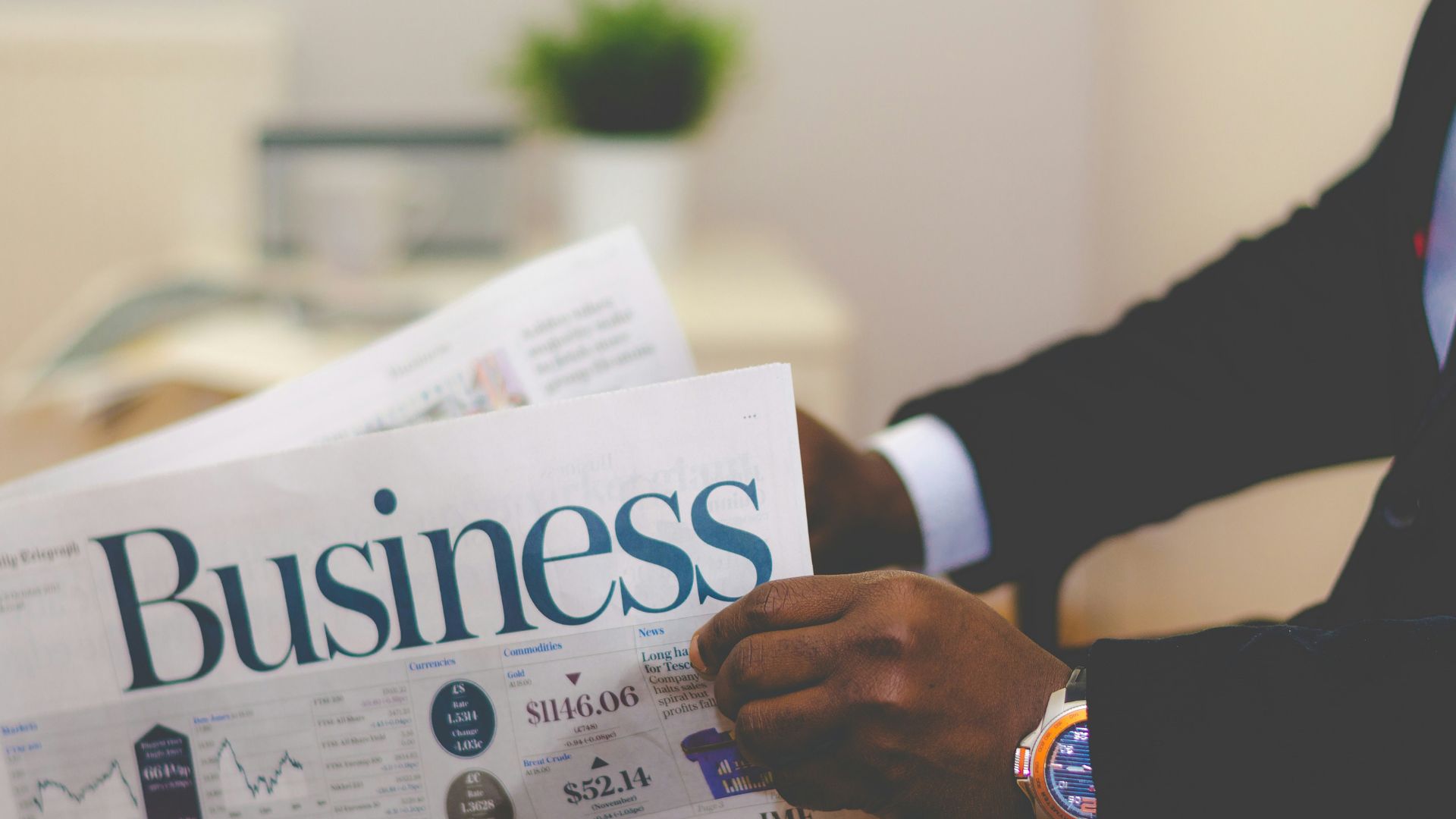 An African man reading a business newspaper. Photo taken by Adeolu Eletu.