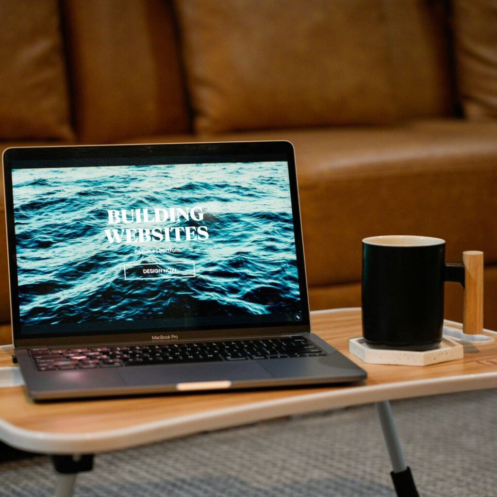 A Laptop on a coffee table with the words building websites.